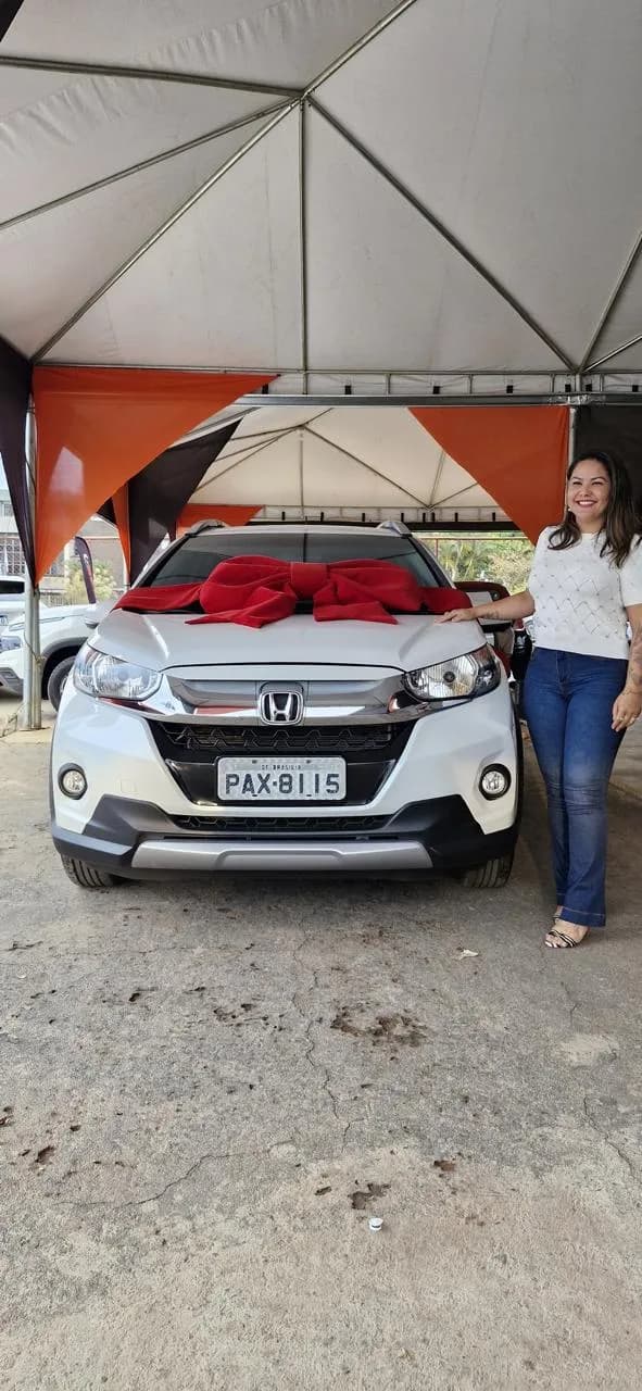 Mulher ao lado de um SUV branco em estacionamento coberto