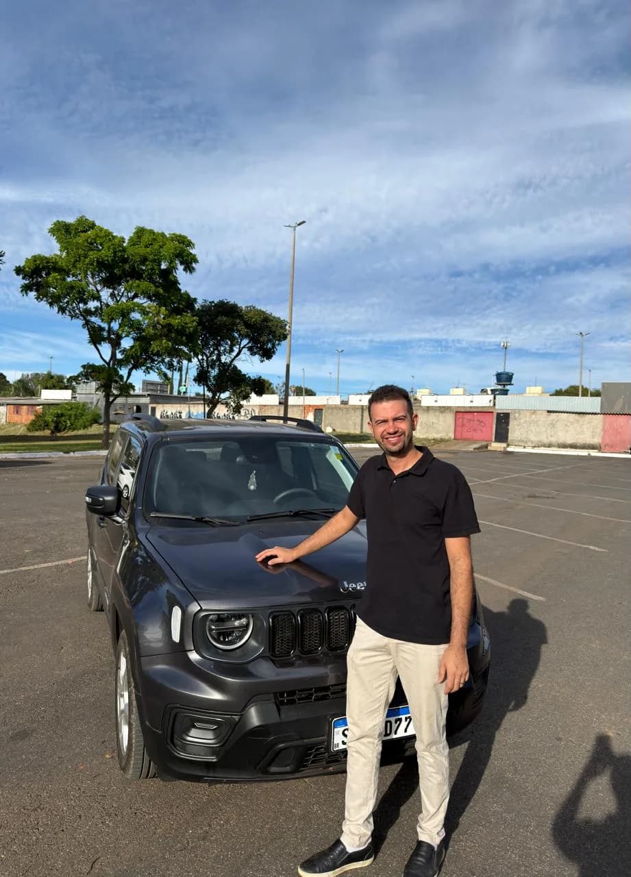 Homem apontando para um SUV preto em estacionamento ao ar livre