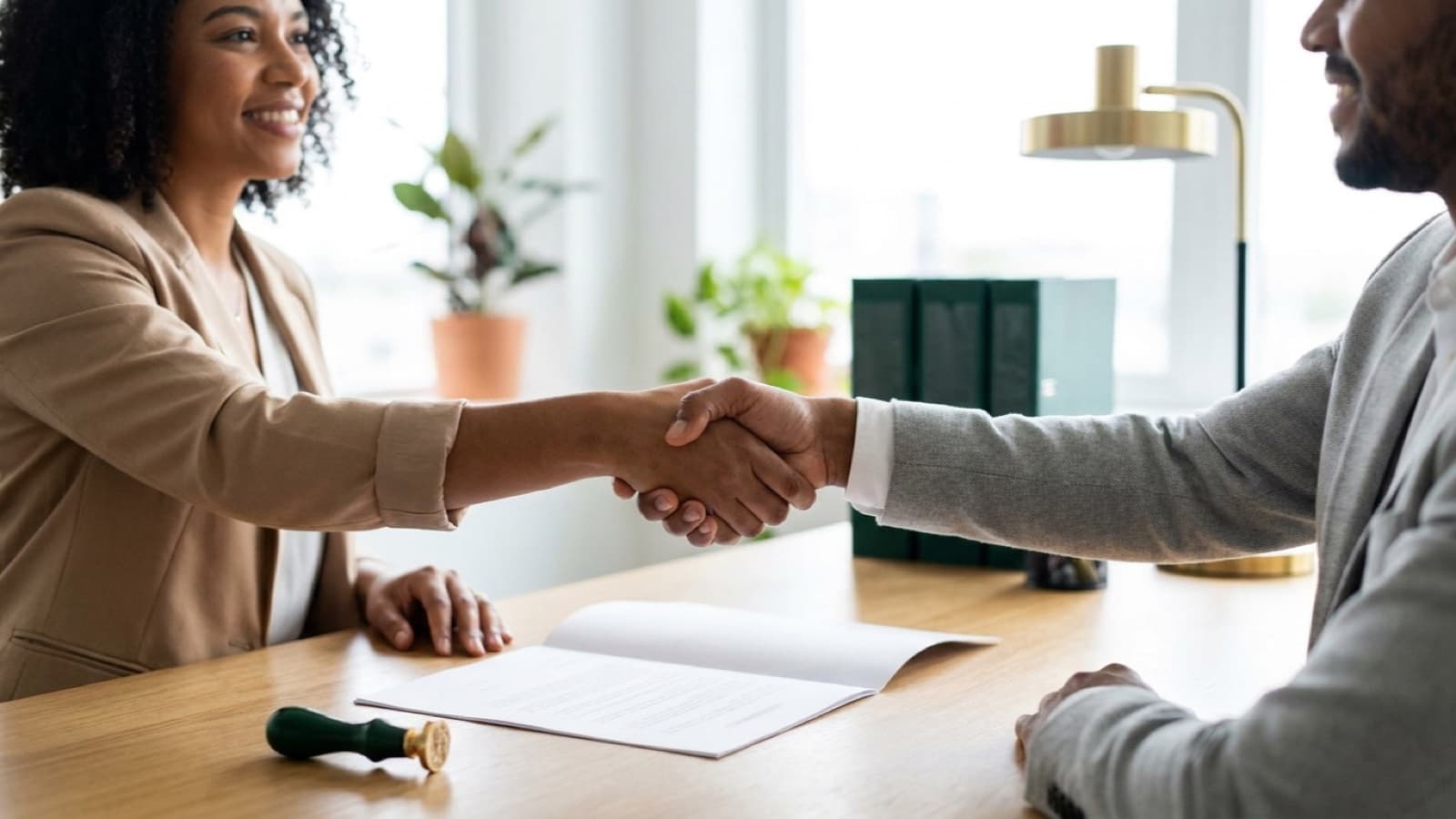 Aperto de mãos sobre um contrato em um escritório